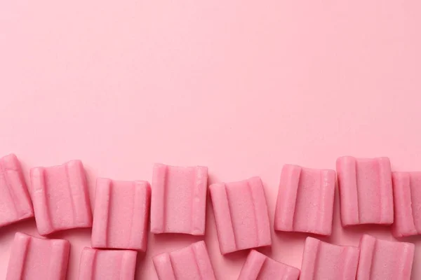 Tasty chewing gums on pink background, flat lay. Space for text