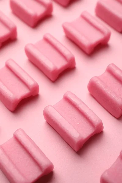 Tasty chewing gums on pink background, closeup