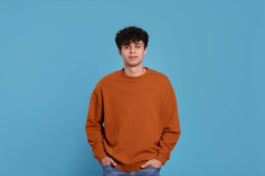Portrait of handsome young man on light blue background