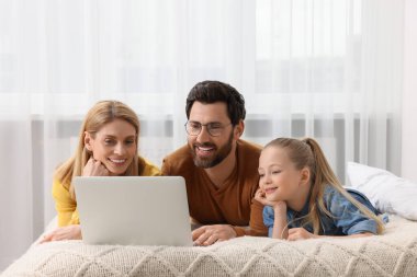 Mutlu aile ile evde yatak üstünde laptop