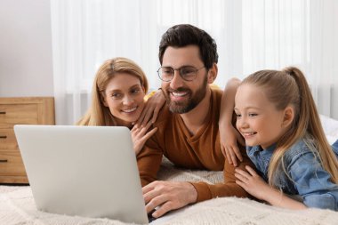 Mutlu aile ile evde yatak üstünde laptop