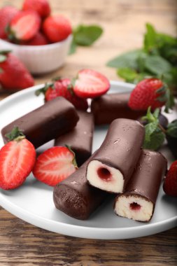 Lezzetli kremalı aperatifler taze çilekler ve ahşap masada nane şekeri.