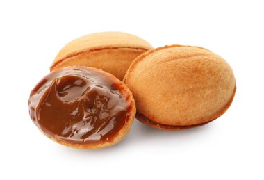 Lezzetli fındık şekilli kurabiyeler ve beyaz arka planda haşlanmış konsantre süt.