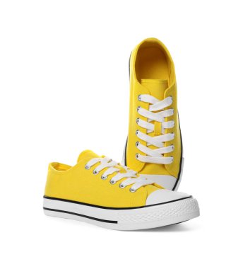 Beyaz arka planda bir çift sarı klasik eski moda spor ayakkabı.