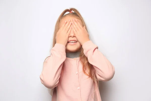 Ευτυχισμένο Κοριτσάκι Που Κλείνει Μάτια Της Χέρια Λευκό Φόντο — Φωτογραφία Αρχείου