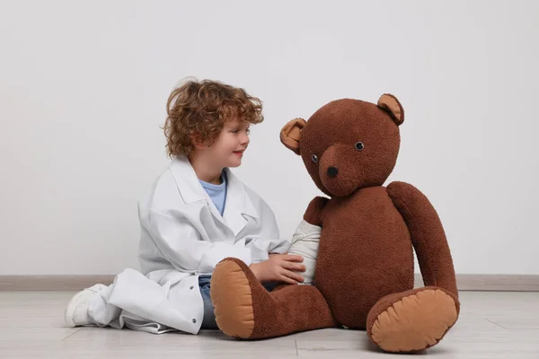 Mały Chłopiec Mundurze Medycznym Niedźwiedź Zabawka Bandażem Wewnątrz — Zdjęcie stockowe