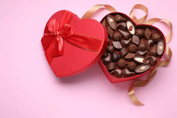 心形盒子 有美味的巧克力糖果和带淡粉色背景 案文的篇幅 — 图库照片