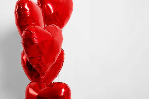 Many red heart shaped balloons on white background, closeup. Space for text