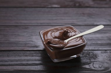 Lezzetli çikolata ezmeli kase ve ahşap masada kaşık. Metin için boşluk