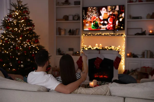 居心地の良い部屋でテレビを通してクリスマス映画を見ているカップル バックビュー 冬の休日の雰囲気 — ストック写真