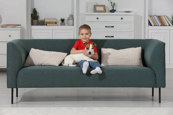 小男孩带着他可爱的狗在家里的沙发上 可爱的宠物 — 图库照片