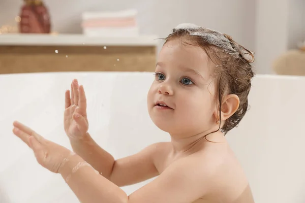 可爱的小女孩在浴室用洗发水洗头发 — 图库照片