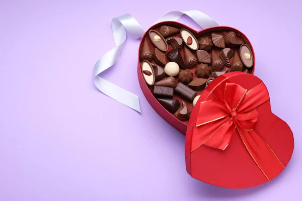 Caixa Forma Coração Com Deliciosos Doces Chocolate Fita Fundo Lilás — Fotografia de Stock