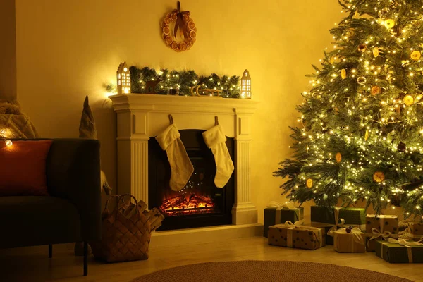 stock image Stylish fireplace near decorated Christmas tree and accessories in cosy room