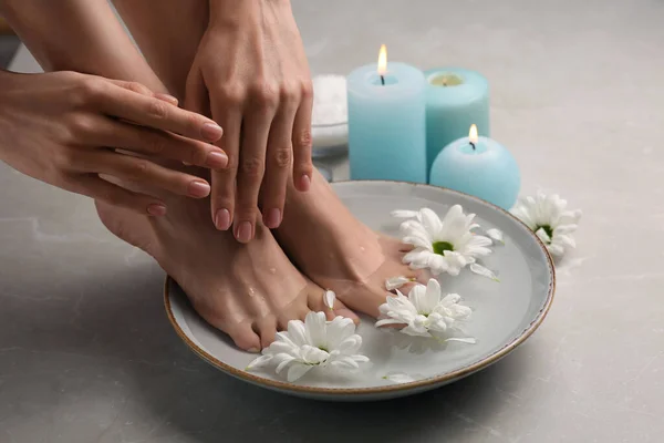 Kvinna Blötläggning Fötterna Skål Med Vatten Och Blommor Grå Marmor — Stockfoto