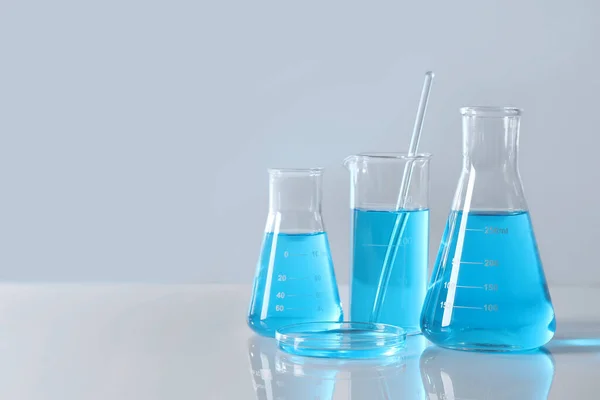 Diferentes Cristalería Laboratorio Con Líquido Azul Claro Mesa Espacio Para —  Fotos de Stock