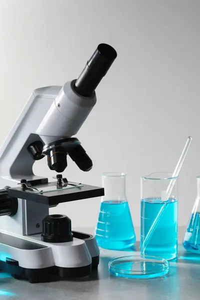 Olika Laboratorieglas Med Ljusblå Vätska Och Mikroskop Bordet — Stockfoto