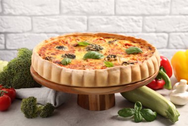 Lezzetli ev yapımı sebzeli kiş ve malzemeler masada.