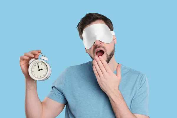 Hombre Cansado Con Máscara Sueño Despertador Sobre Fondo Azul Claro — Foto de Stock