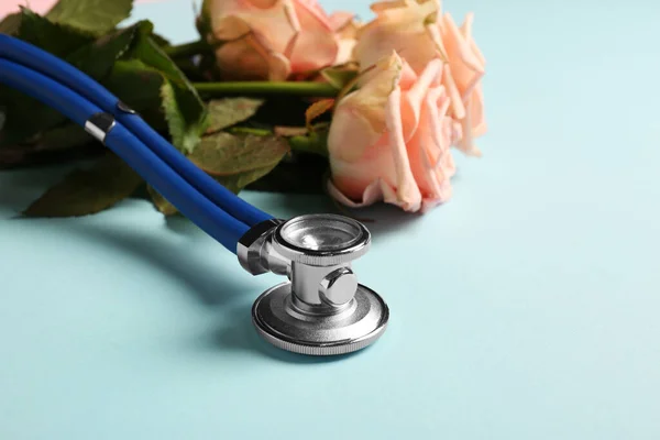 Stethoscope Και Λουλούδια Γαλάζιο Φόντο Closeup Χώρο Για Κείμενο Ευτυχισμένη — Φωτογραφία Αρχείου