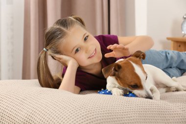 Evde, sevimli köpeğiyle yatakta sevimli bir kız. Sevimli hayvan.