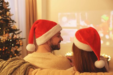 Çift odada video projektörünün yanında vakit geçiriyor. Noel atmosferi