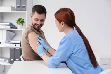 Doktor klinikteki hastaya hepatit aşısı veriyor.