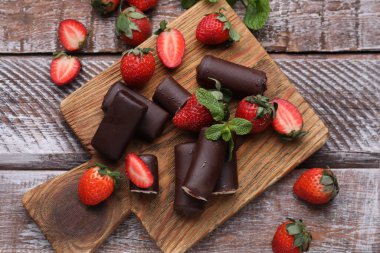 Lezzetli kremalı aperatifler taze çilekler ve ahşap masa üzerinde nane şekeri.