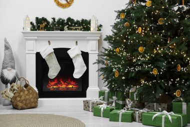 Şöminesi ve Noel ağacının altında hediyeleri olan rahat bir oturma odası. İç tasarım