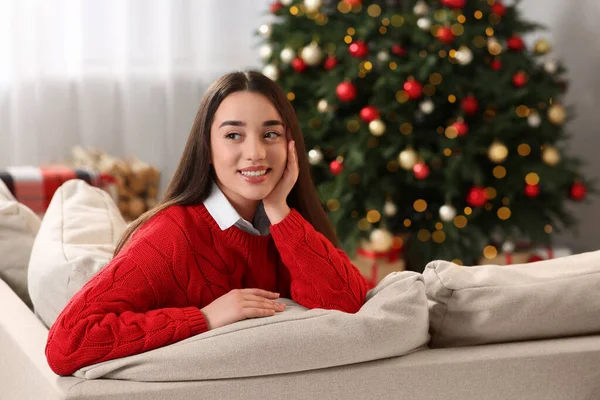 Evdeki Noel Ağacının Yanındaki Kanepede Gülümseyen Kadın — Stok fotoğraf