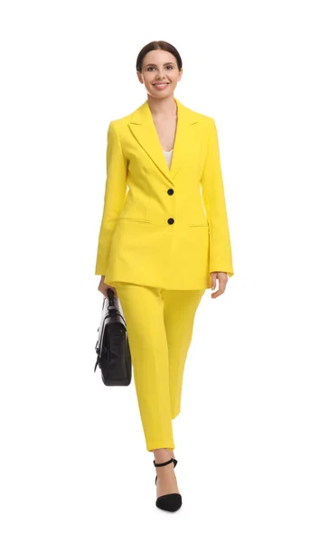 白い背景を歩くブリーフケース付き黄色のスーツの美しいビジネス女性 — ストック写真