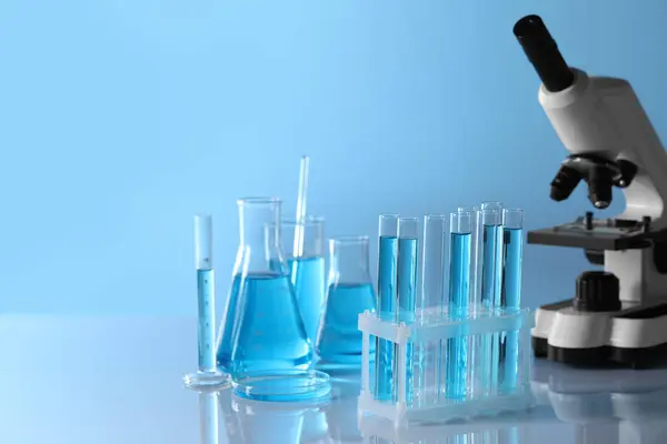 Мікроскоп Біля Різних Лабораторних Скляних Посуду Пробірки Світло Блакитною Рідиною — стокове фото