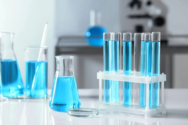 Tubos Ensayo Con Líquido Azul Claro Diferentes Cristalería Laboratorio Mesa —  Fotos de Stock