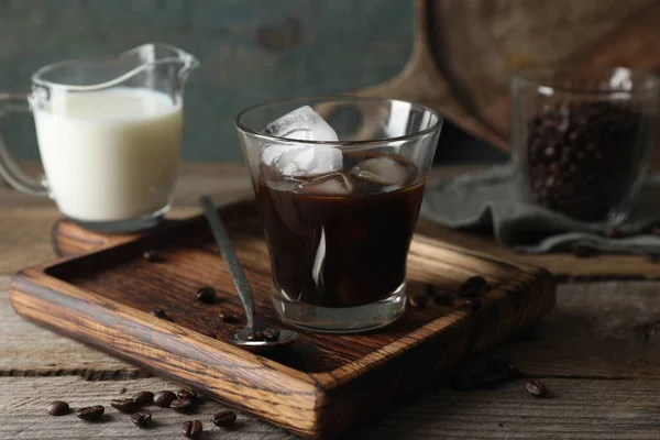 木製のテーブルの上においしいアイスコーヒー ミルク 豆のガラス — ストック写真