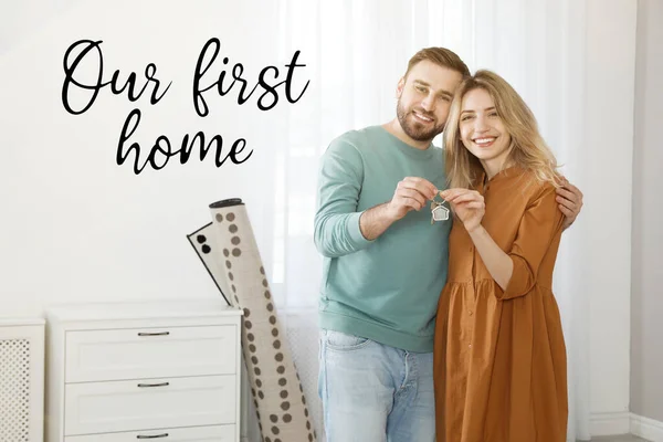 First-time buyer. Happy young couple with key in their new house and phrase Our Fisrt Home