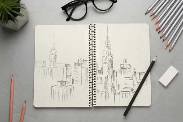 Defterdeki Kalemlerdeki Silgideki Gri Masadaki Gözlüklerdeki Şehir Manzarasının Çizimi — Stok fotoğraf