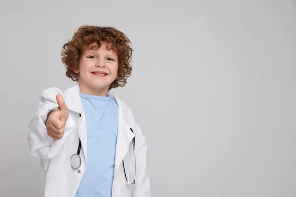 Liten Pojke Medicinsk Uniform Med Stetoskop Visar Tummen Upp Ljusgrå — Stockfoto