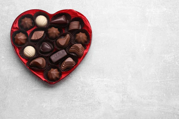 Hjärtformad Ask Med Läckra Chokladgodis Ljusgrått Bord Ovanifrån Plats För — Stockfoto