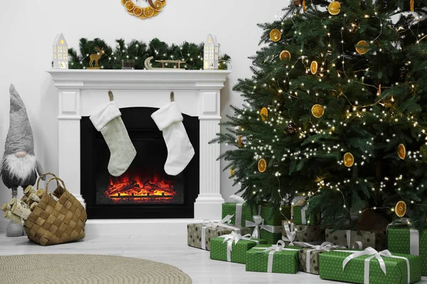 暖炉とクリスマスツリーの下で贈り物と居心地の良いリビングルーム インテリアデザイン — ストック写真