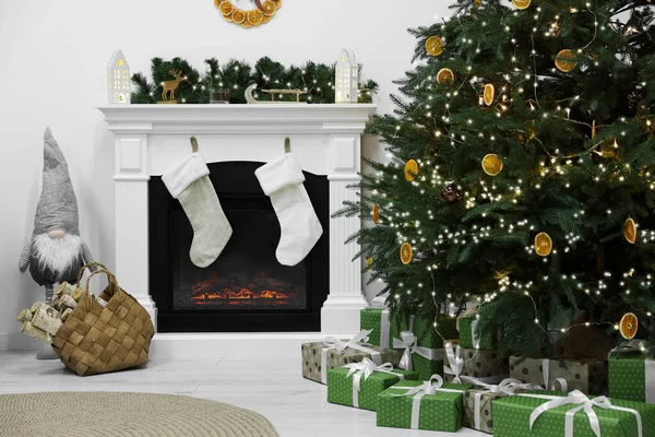 暖炉とクリスマスツリーの下で贈り物と居心地の良いリビングルーム インテリアデザイン — ストック写真