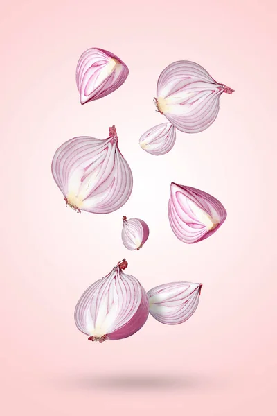 Cut Red Onions Falling Light Pink Background — Stock Photo, Image