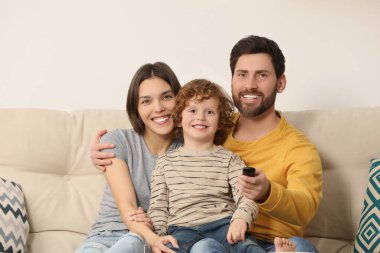 Happy family watching TV on sofa indoors