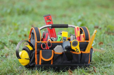 Dışarıdaki çimlerin tamiri için farklı aletlerle dolu çantalar.