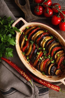 Lezzetli ratatouille ve malzemeler masada, düz yerde.