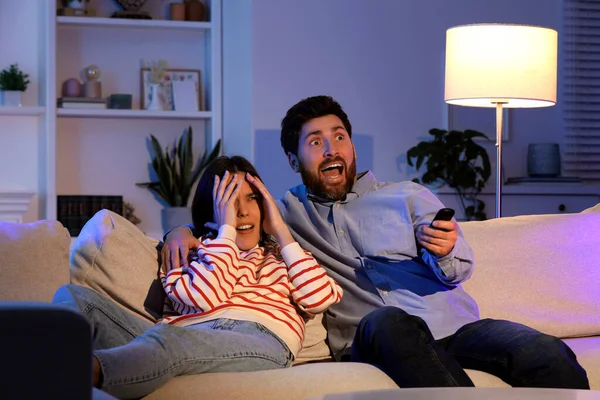 Przerażona Para Ogląda Telewizję Kanapie Domu — Zdjęcie stockowe