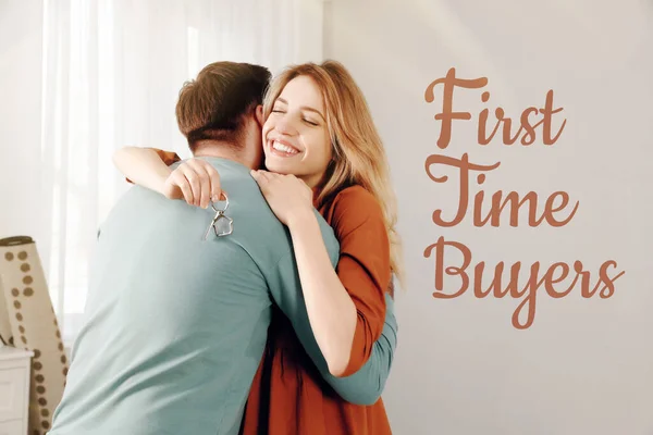 First-time buyer. Happy young couple with key hugging in their new house