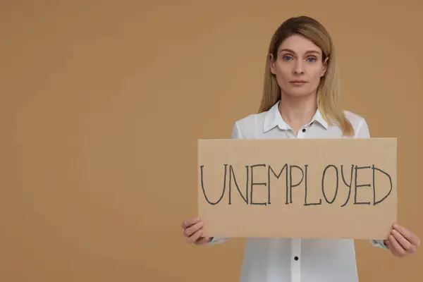 Frau Mit Schild Mit Dem Wort Arbeitslos Auf Beigem Hintergrund — Stockfoto