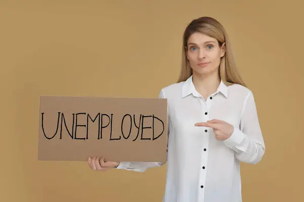 Vrouw Met Teken Met Woord Werklozen Beige Achtergrond — Stockfoto