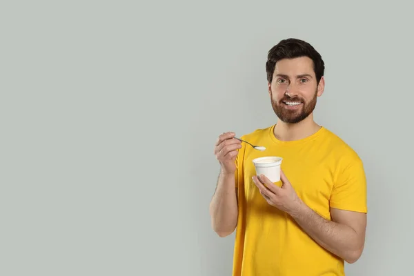 Bell Uomo Con Delizioso Yogurt Cucchiaio Sfondo Grigio Chiaro Spazio — Foto Stock