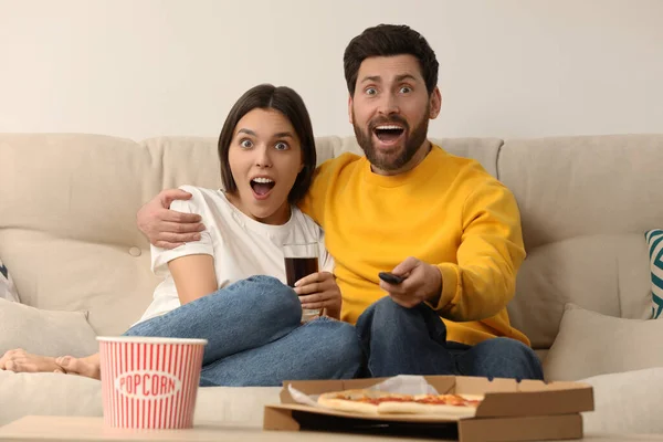Zaskoczona Para Ogląda Telewizję Popcornem Pizzą Kanapie Domu — Zdjęcie stockowe